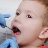 Niño con dientes de leche en la consulta del dentista