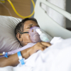 Mujer mayor con ventilador en la cama de un hospital