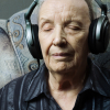 Hombre mayor escuchando música con los ojos cerrados.