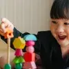 Niña oriental jugando con construcciones de madera