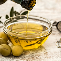 Aceite de oliva cayendo de una aceitera en un bol