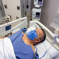 Hombre hospitalizado en una cama en la UCI